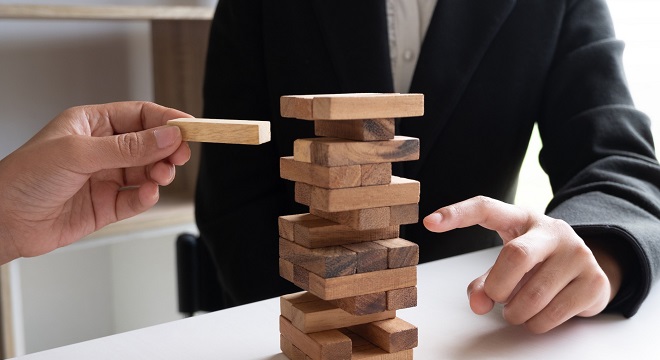 deux personnes jouent au Jenga jeu d'équilibre qui consste à enlever des pièces d'une tour en bois sans que cela s'effondre