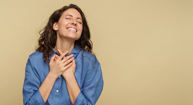 Une femme exprimant la joie les mains sur le cœur