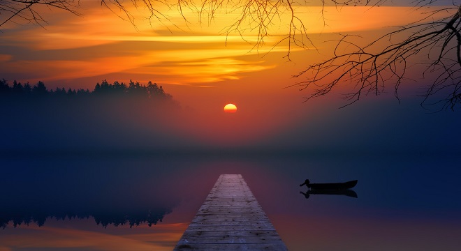 Bord d'un lac très calme au lever du soleil