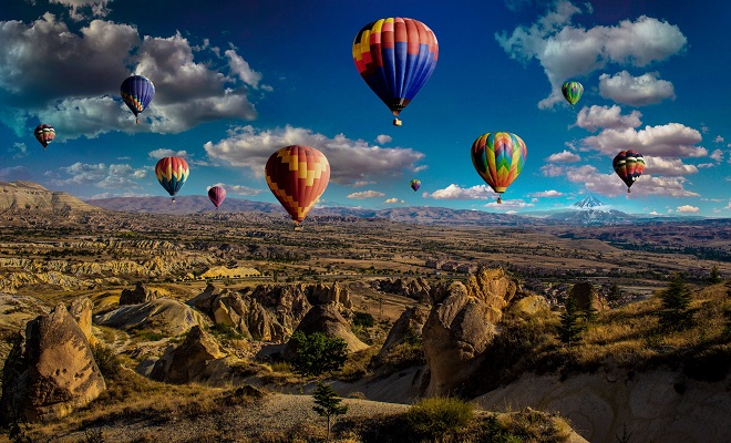 Un groupe de montgolfières survolant un paysage rocailleux