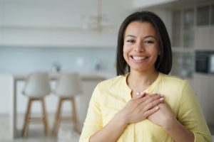 Une femme la main sur le cœur en signe de gratitude