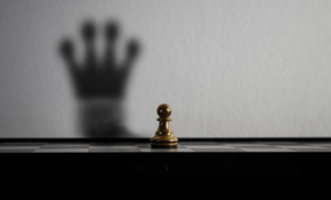 Un pion sur un échiquier dont l'ombre reflète celle d'un roi