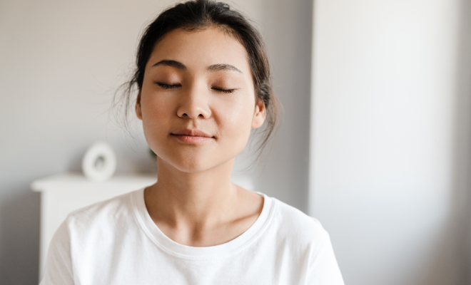 Une femme en méditation, en introversion les yeux fermés