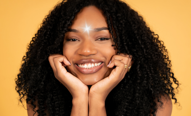 Visage souriant d'une femme avec une étoile rayonnante au centre du front symbolisant l'âme, l'être spirituel