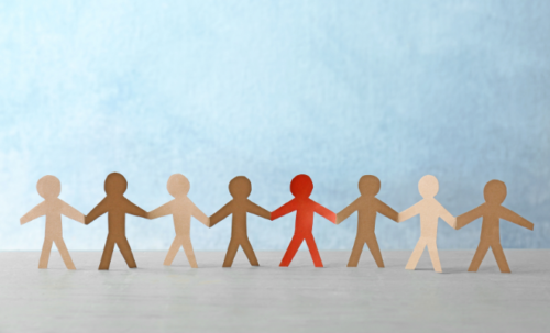 Des personnages en découpage papier de différentes couleur se tenant par la main