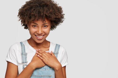 Jeune femme joignant ses mains sur son coeur