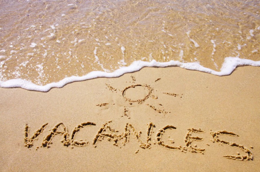 Le mot vacances écrit sur la plage