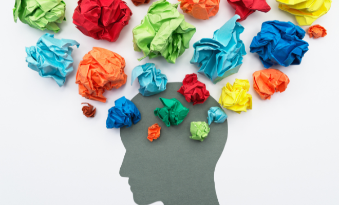 Boules de papier froissé de différentes couleur sortant d'une tête humaine en dessin