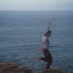homme heureux qui court dans les rochers près de la mer