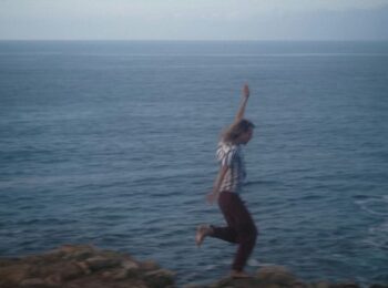 homme heureux qui court dans les rochers près de la mer