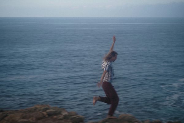 homme heureux qui court dans les rochers près de la mer