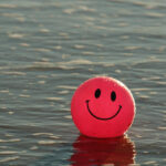 Ballon rouge dans l'eau avec un dessin de visage souriant