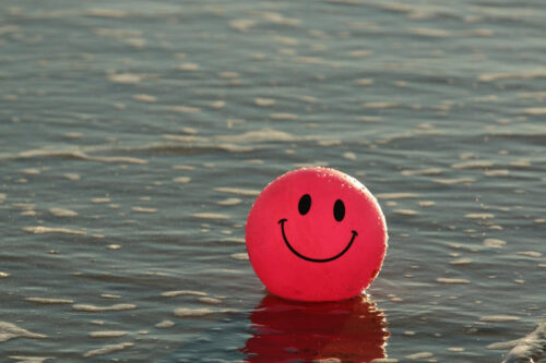Ballon rouge dans l'eau avec un dessin de visage souriant 