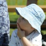 enfant avec un chapeau qui regarde au loin et semble réfléchir