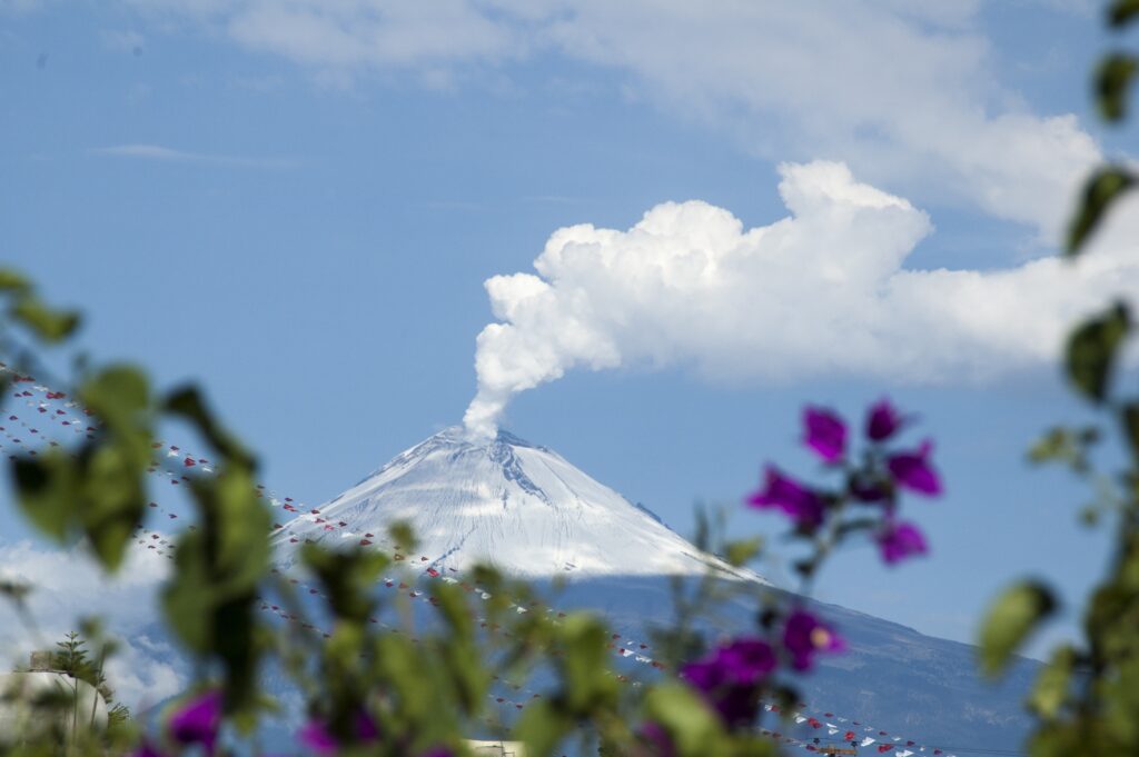 sommet d'une montagne en fond avec de la fumée qui s'échappe en haut
