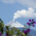 sommet d'une montagne en fond avec de la fumée qui s'échappe en haut