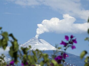 sommet d'une montagne en fond avec de la fumée qui s'échappe en haut