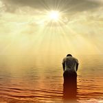 Homme tête baissée face au soleil et ses rayons