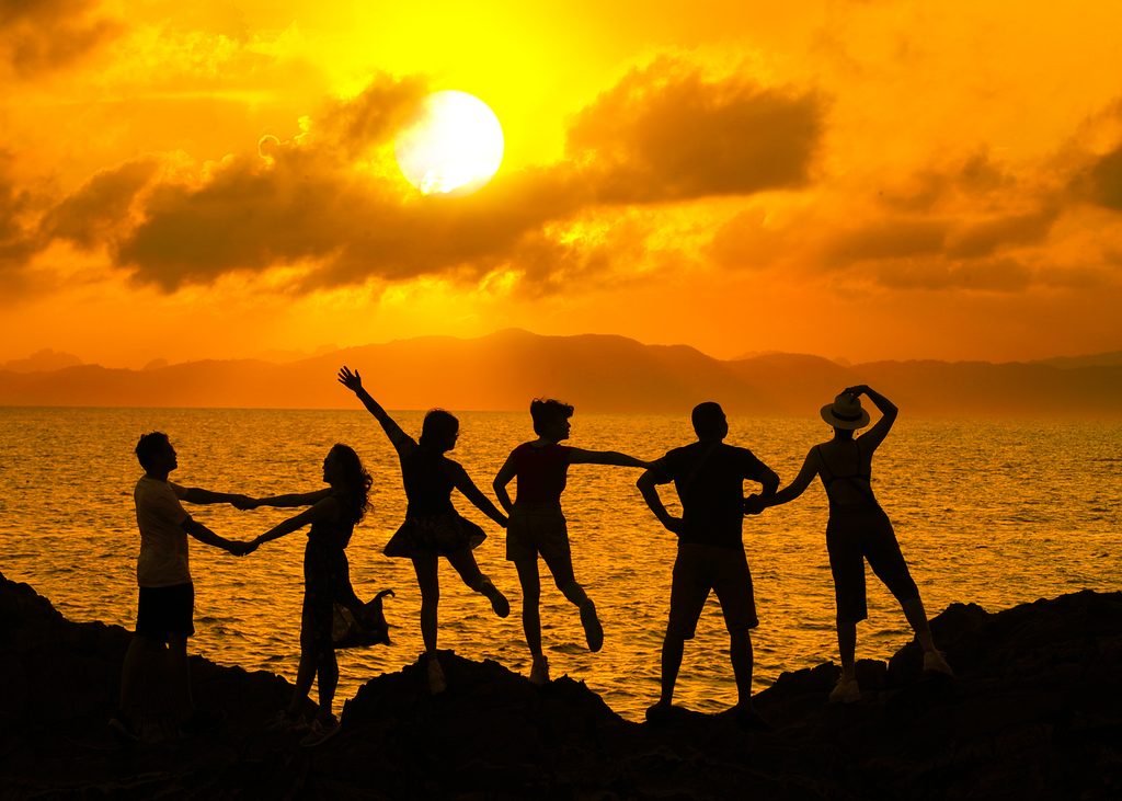 Personnes qui dansent au coucher du soleil