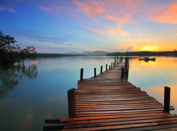 Un ponton qui donne sur un lac aux heures matinales