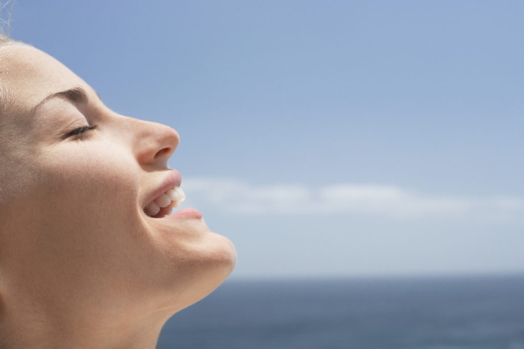 Femme qui sourit face au soleil